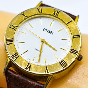 Große, goldfarbene Damenuhr mit weißem Ziffernblatt