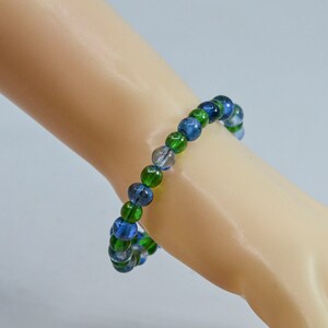 May include: A blue and green beaded bracelet with an elastic band.
