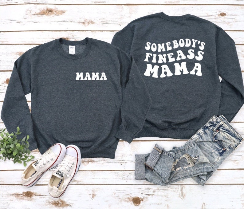 May include: Two dark gray sweatshirts with white text. One sweatshirt says "Mama" and the other says "Somebody's Fineass Mama".