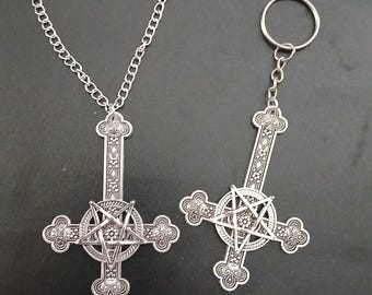 May include: Two silver-colored pendants featuring a cross design with a pentagram in the center. One pendant is on a chain, the other is a keychain. The pendants have ornate detailing and are set against a dark background.