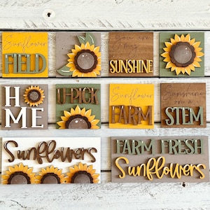 May include: A set of nine wooden signs with sunflower and farm-themed text. The signs are painted in various shades of brown, yellow, and green. The text on the signs includes "Sunflower Field", "You Are My Sunshine", "Home", "U-Pick", "Sunflower Farm", "Sunshine on a Stem", "Sunflowers", and "Farm Fresh Sunflowers".
