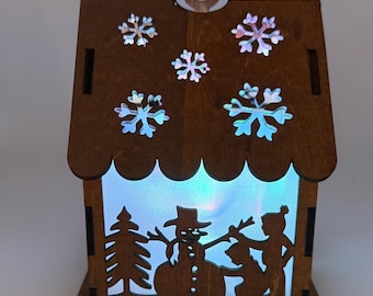 Snowman lighted cabin with battery operated led puck light.