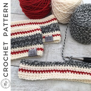 Può includere: Due scaldatasse da caffè all'uncinetto con un motivo a righe di filato bianco, rosso e grigio. Gli scaldatasse sono appoggiati su una superficie di legno con gomitoli di filato sullo sfondo. Gli scaldatasse hanno etichette che recitano "Through the Loop - Yarn Craft".