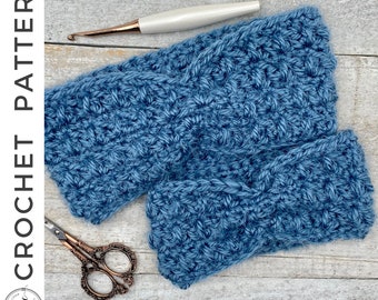May include: Two blue crocheted headbands on a wooden surface. One headband is folded in half and the other is laid out flat. A pair of scissors and a crochet hook are also visible.
