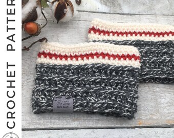 May include: Two gray and white crocheted cup cozies with a red and white stripe detail. The cozies are on a white wooden surface. The label on one of the cozies reads "Through The Loop - Yarn Craft".