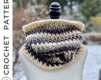 May include: A crocheted cowl in cream, gray, and purple stripes. The cowl is displayed on a white mannequin.