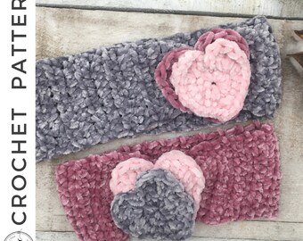 May include: Two crocheted headbands with heart-shaped embellishments. One headband is gray and the other is pink. Both headbands have a fuzzy texture.