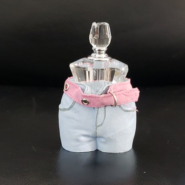 Cut Crystal Perfume Bottle With Rose Design On Top, Wearing stone denim shorts with cloth  pink belt decoration.