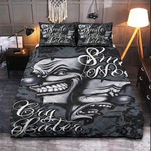 May include: A black and white quilt with a graphic design of a smiling face and the text "Smile Now Cry Later".