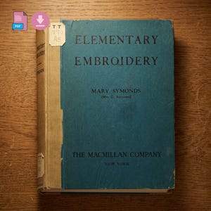 Puede incluir: Un libro antiguo titulado "Elementary Embroidery" de Mary Symonds. El libro tiene una cubierta de color verde azulado con texto negro y una lomo beige. "The Macmillan Company, New York" está impreso en la cubierta. Una pequeña etiqueta blanca está adjunta.