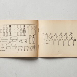 May include: An open vintage book with illustrations of toys and a crested crane. The left page shows step-by-step drawings of toy soldiers, pigs, sheep, and other figures. The right page features a series of drawings of a crested crane.