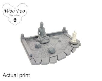 May include: A gray 3D printed zen garden with a small Buddha statue, a miniature figure, and a path of stones.