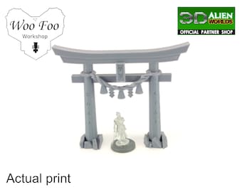 May include: A gray 3D printed miniature of a traditional Japanese torii gate with a small figure standing in the center. The gate has a rope with bells hanging from it. The gate is printed with Japanese characters.