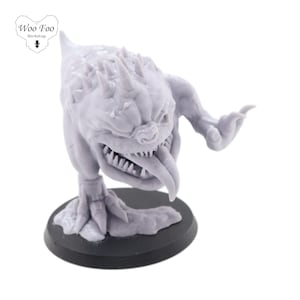 Puede incluir: Una miniatura gris, impresa en 3D, de una criatura grotesca, con púas y dientes afilados, con una lengua larga. La criatura está de pie sobre una base negra.