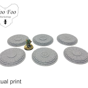 Könnte beinhalten: Sechs graue runde Sockel mit komplizierten Designs, jeder Sockel besteht aus drei übereinanderliegenden Ringen. Die Sockel sind aus einem strukturierten Material gefertigt und haben ein kreisförmiges Design in der Mitte.