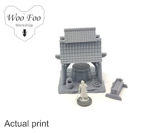 May include: A 3D printed miniature set featuring a Japanese-style building with a tiled roof, a well, a small wooden structure, and a miniature figure. The set is painted in a gray color.