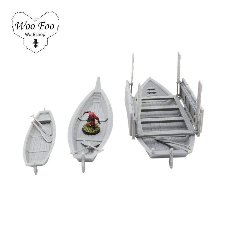 May include: Three grey miniature boats of varying sizes. The boats include oars and a small figure in one boat. The boats are designed for tabletop gaming or model building. The image includes the text "Woo Foo Workshop".