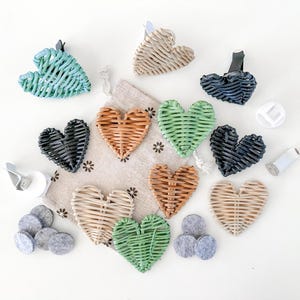 May include: A selection of heart-shaped woven rattan car air fresheners in various colours, including green, black, tan, and orange. The image also shows felt pads and car vent clips.