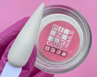 Puede incluir: Un polvo blanco para uñas en un frasco transparente con una etiqueta rosa que dice "PINK CODE NAILS #037".