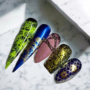 May include: Five different nail designs featuring gold foil accents. The designs include a green and gold floral pattern, a blue and gold snake pattern, a pink and gold chain pattern, a brown and gold leopard print pattern, and a blue and gold geometric pattern.