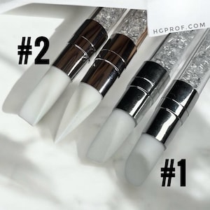 May include: Three nail art tools with white silicone tips and clear handles with glitter. The handles are labelled #1 and #2.