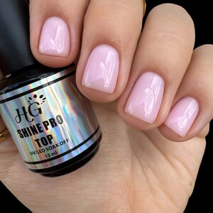 May include: A clear bottle of HG Shine Pro Top UV/LED Soak Off nail polish. The bottle is 15 ml and has a holographic label with the brand name and product name.