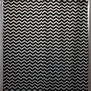 May include: Black and white chevron patterned shower curtain. The curtain is made of fabric and has a simple design.