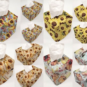 May include: A set of 10 tissue box covers featuring various fall-themed designs. The designs include sunflowers, pumpkins, and fall leaves in shades of yellow, orange, brown, and blue.