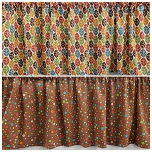 May include: Two fabric valances with different patterns. The top valance has a white background with a repeating pattern of brown, orange, yellow, and blue leaves. The bottom valance has a brown background with a repeating pattern of colorful circles.