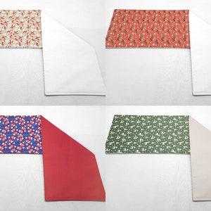 May include: Four table runners with different Christmas patterns. The runners are white, red, beige, and green. Each runner has a different pattern of Christmas trees, snowflakes, and Santa Claus figures.