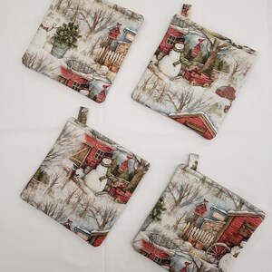 May include: Set of four winter-themed pot holders featuring a snowman, a red house, and a snowy landscape. The pot holders are made of fabric and have a loop for hanging.