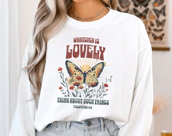 Puede incluir: Sudadera blanca de manga larga con un gráfico de mariposa y el texto "Whatever is Lovely Think about such things Philippians 4:8".
