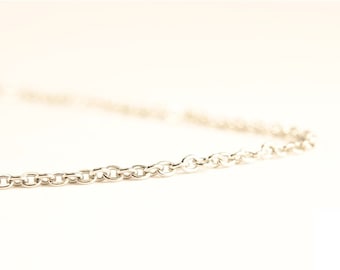 May include: A silver-colored chain necklace with a series of small, rounded links. The chain is displayed against a white background, with the focus on the chain's texture and design. The necklace is a simple, elegant piece of jewelry.