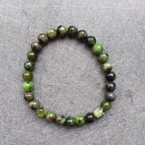 Peut inclure: Un bracelet en pierres précieuses vertes et noires avec des perles rondes.