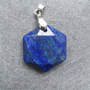 Peut inclure: Un pendentif en lapis-lazuli bleu foncé avec une bélière en métal argenté. Le pendentif est en forme d'étoile à six branches.