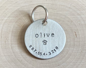 a simple personalized dog id tag for collar with name and phone number symbol hand stamped lightweight aluminum round 1" lost pet cat tag