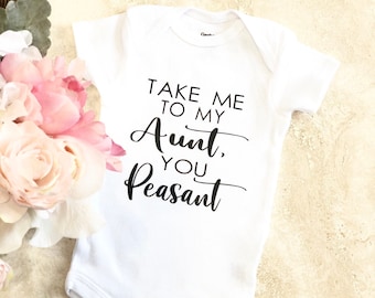 May include: White baby onesie with black text that reads "Take me to my Aunt, you Peasant".