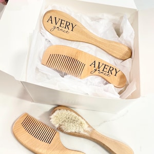 May include: A set of three wooden baby hair care tools in a white box. The set includes a comb, a brush, and a hairbrush. The hairbrush and comb are personalized with the name "Avery Grace".