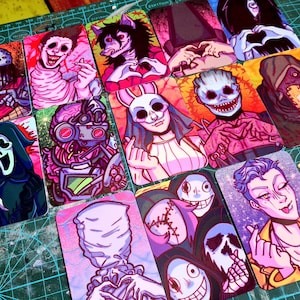 Puede incluir: Una colección de tarjetas ilustradas con varios personajes de terror. Las tarjetas muestran una variedad de diseños, incluyendo figuras con máscaras, monstruos y retratos estilizados, todos renderizados en colores vibrantes y líneas audaces.