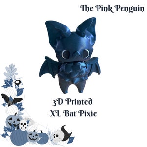 May include: A 3D printed blue bat pixie figurine with large eyes and wings. The figurine is standing on a white background. The text "The Pink Penguin" and "3D Printed XL Bat Pixie" is visible in the image.