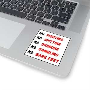 Puede incluir: Una pegatina blanca con texto negro y letras rojas que dice "NO FIGHTING, NO SPITTING, NO DRINKING, NO GAMBLING, NO BARE FEET". La pegatina está colocada en un portátil plateado.
