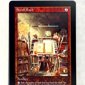 May include: A black card with a detailed illustration of a room filled with books, a desk, and a skull chair. The card is labeled "Scroll Rack" and "Artifact" with game instructions. The number "2" is in the top right corner.