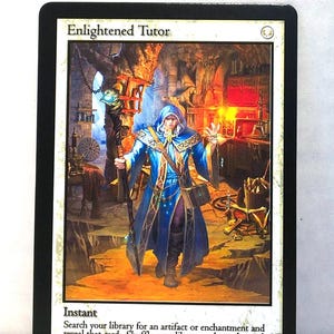 May include: A collectible card titled "Enlightened Tutor" with a fantasy illustration. The artwork depicts a robed figure in blue and gold, holding a staff, in a dimly lit chamber. The card's text describes its function within a game.