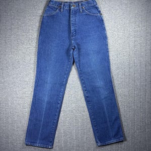 K&ouml;nnte beinhalten: Blaue Jeans aus Denim mit hohem Bund und geradem Bein. Die Jeans haben ein klassisches F&uuml;nf-Taschen-Design, einen Knopf- und Rei&szlig;verschluss sowie G&uuml;rtelschlaufen. Der Denim hat eine mittelblaue Waschung mit dezenten Ausbleichungen und Abnutzungen.