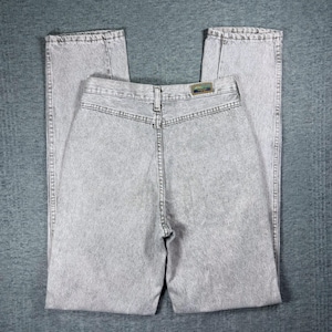 Peut inclure: Jean clair d&eacute;lav&eacute; &agrave; l'acide. Le jean a une taille haute et une coupe droite. Le dos du jean est visible, montrant les poches, les passants de ceinture et une petite &eacute;tiquette. Le tissu a un aspect textur&eacute;.