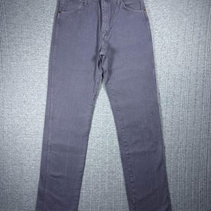May include: A pair of gray denim jeans. The jeans have a classic five-pocket design, a button and zipper closure, and belt loops. The jeans are made of a durable denim fabric and have a straight leg fit.