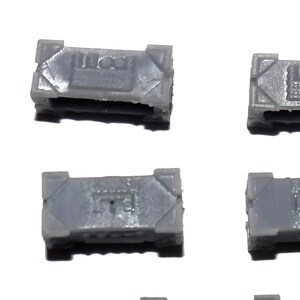 May include: Five gray plastic rectangular boxes with different designs on the top. The boxes are all the same size and shape.