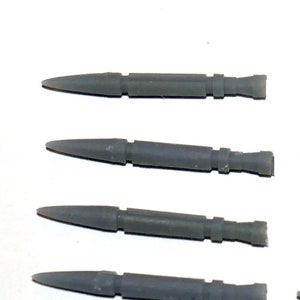 May include: Ten gray plastic model rockets with pointed noses and fins. The rockets are all the same size and shape.