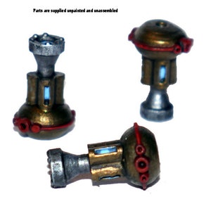 May include: Three miniature, unpainted and unassembled, metallic-looking components. Each has a gold-colored body with red accents and a silver-colored base. The components have a blue rectangular detail. The text "Parts are supplied unpainted and unassembled" is visible.