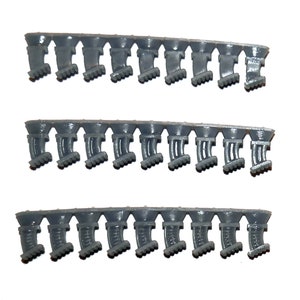 May include: Three rows of gray plastic model parts, each with a series of identical components. The components have a curved shape with a textured base and a smooth top. The parts are connected in a strip.